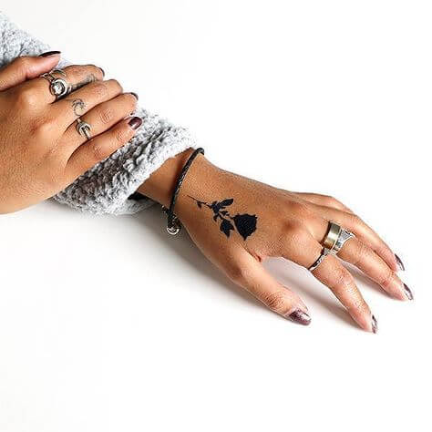 Minimalist black rose tattoo on hand