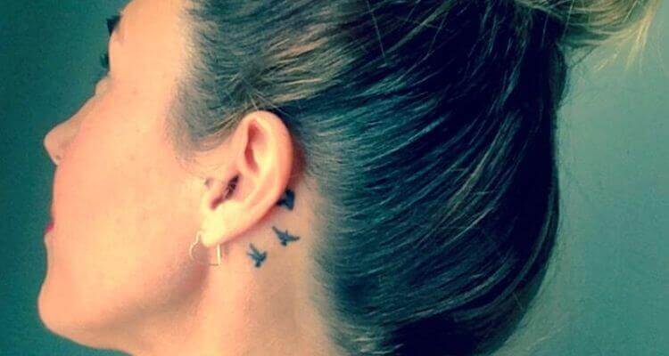 Minimalistic dove tattoo located behind the ear