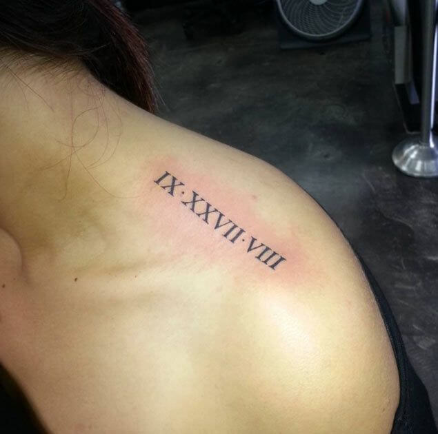 Roman numerals tattoo on the top of shoulder